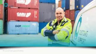 Safety staff member leaning against Customs Support van in Cargo bay