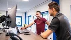 two people looking on the laptop in an office