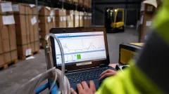 person working on a laptop in a warehouse