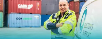 Safety staff member leaning against Customs Support van in Cargo bay